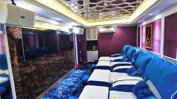 A room with a row of beds, a wall-mounted TV, and a patterned carpet.