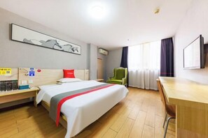 A hotel room with a bed, a desk, a chair, a TV, and a window with curtains. - Yiyi Chain Hotel (Foshan Sanshui Plaza Branch) (Foshan)