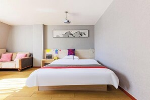 A hotel room with a large bed, a sofa, a nightstand, and a ceiling projector. - Yiyi Chain Hotel (Foshan Sanshui Plaza Branch) (Foshan)
