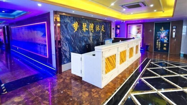 A hotel lobby with a reception desk, a marble floor, and a wall with a large sign. - Yiyi Chain Hotel (Foshan Sanshui Plaza Branch) (Foshan)