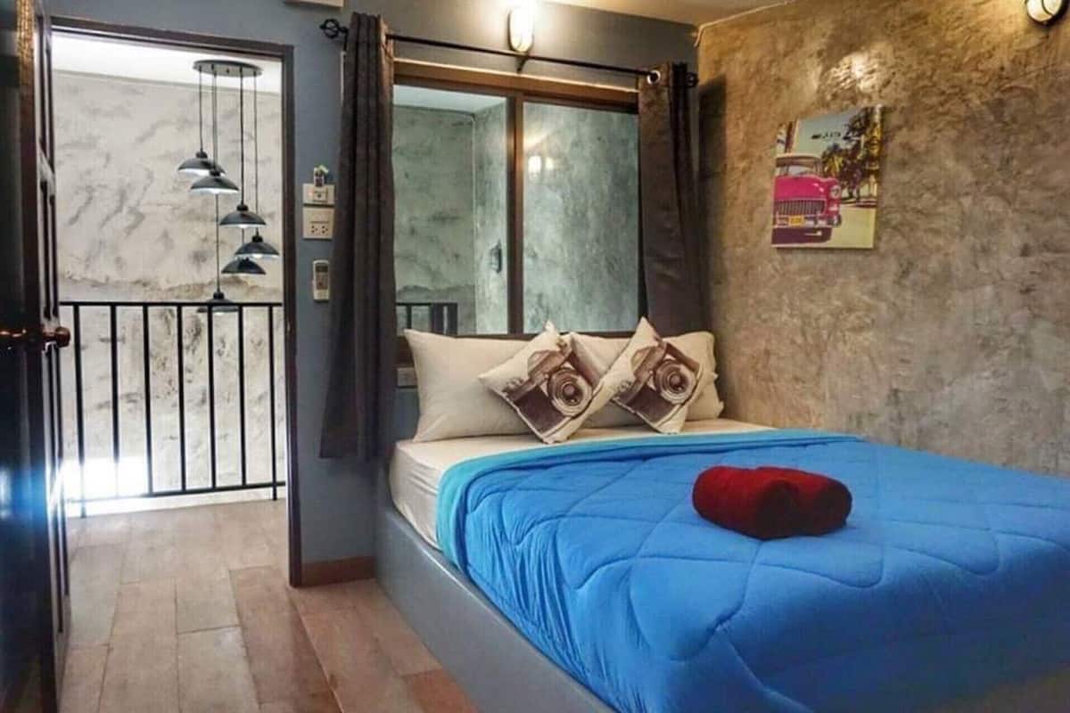 Ein Schlafzimmer mit einem Bett, einem Fenster, einer Tür und einer Wand mit einem Poster.