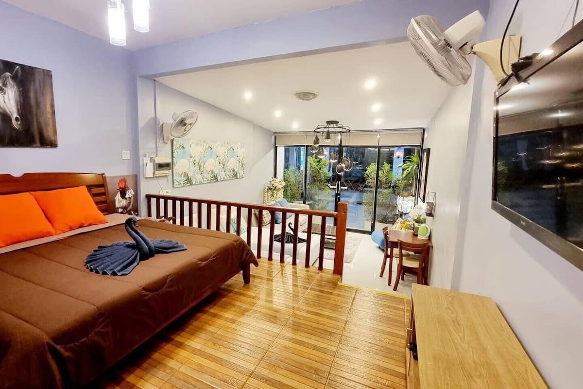 Ein Schlafzimmer mit Bett, Holzboden, Balkon und Blick.