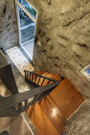 A marble staircase with wooden steps and a metal handrail leading to a glass door. - Baan Bua Talay (Rayong)
