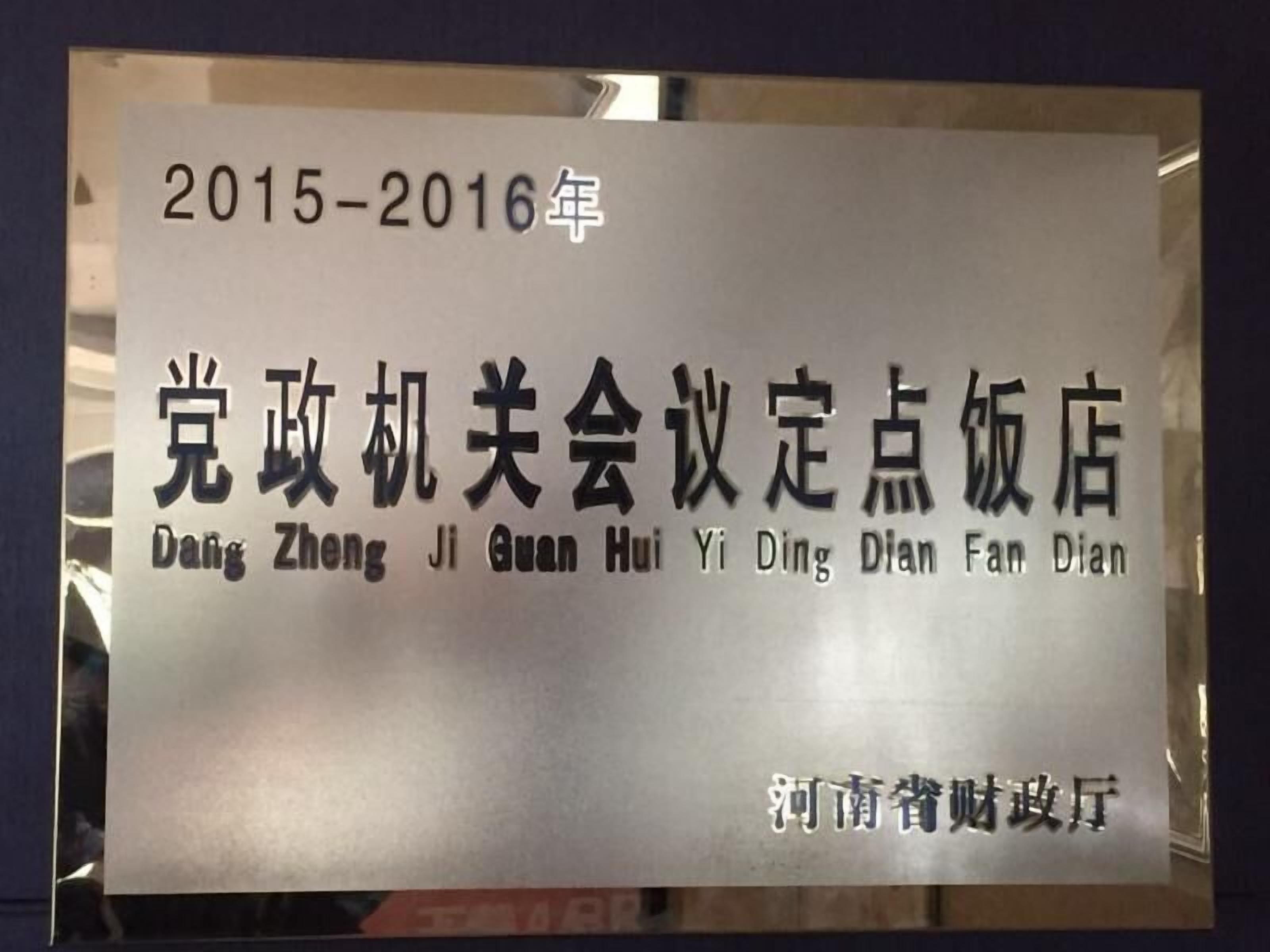 A sign with the text "2015-2016年" and "党政机关会议定点饭店" along with its English translation "Party and Government Agency Meeting Point Restaurant".