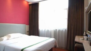 A hotel room with a bed, a desk, and a window with curtains. - Greentree Inn Hebi Hengshan Road Business Hotel (Hebi)