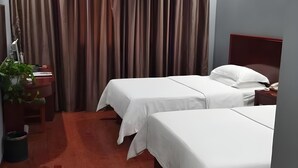 A hotel room with two beds, a desk with a computer, and a plant. - Greentree Inn Hebi Hengshan Road Business Hotel (Hebi)
