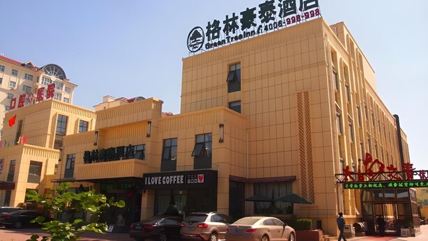 A hotel with a sign for "Love Coffee" and a parking area with cars. - Greentree Inn Hebi Hengshan Road Business Hotel (Hebi)
