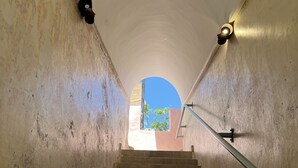 A staircase with a metal handrail, leading to an arched opening. - Charming condo at the heart of Batroun old souk (Batroun)