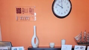 A conference room with a round table, four chairs, a clock, and informational posters on the walls. - Costantinapoli 27 (Naples)