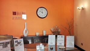A reception area with a clock, a vase, a ship model, and informational brochures. - Costantinapoli 27 (Naples)