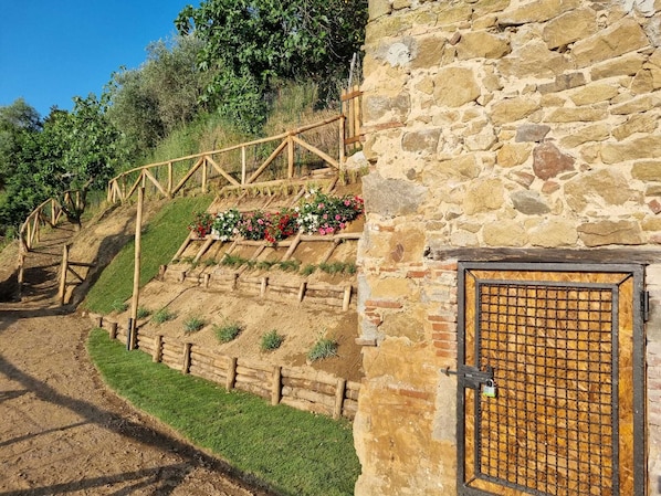 A stone building with a wooden door and a metal gate. - House Chez Paul (Massarosa)