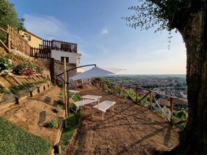 A terrace with outdoor seating and a view of a town.