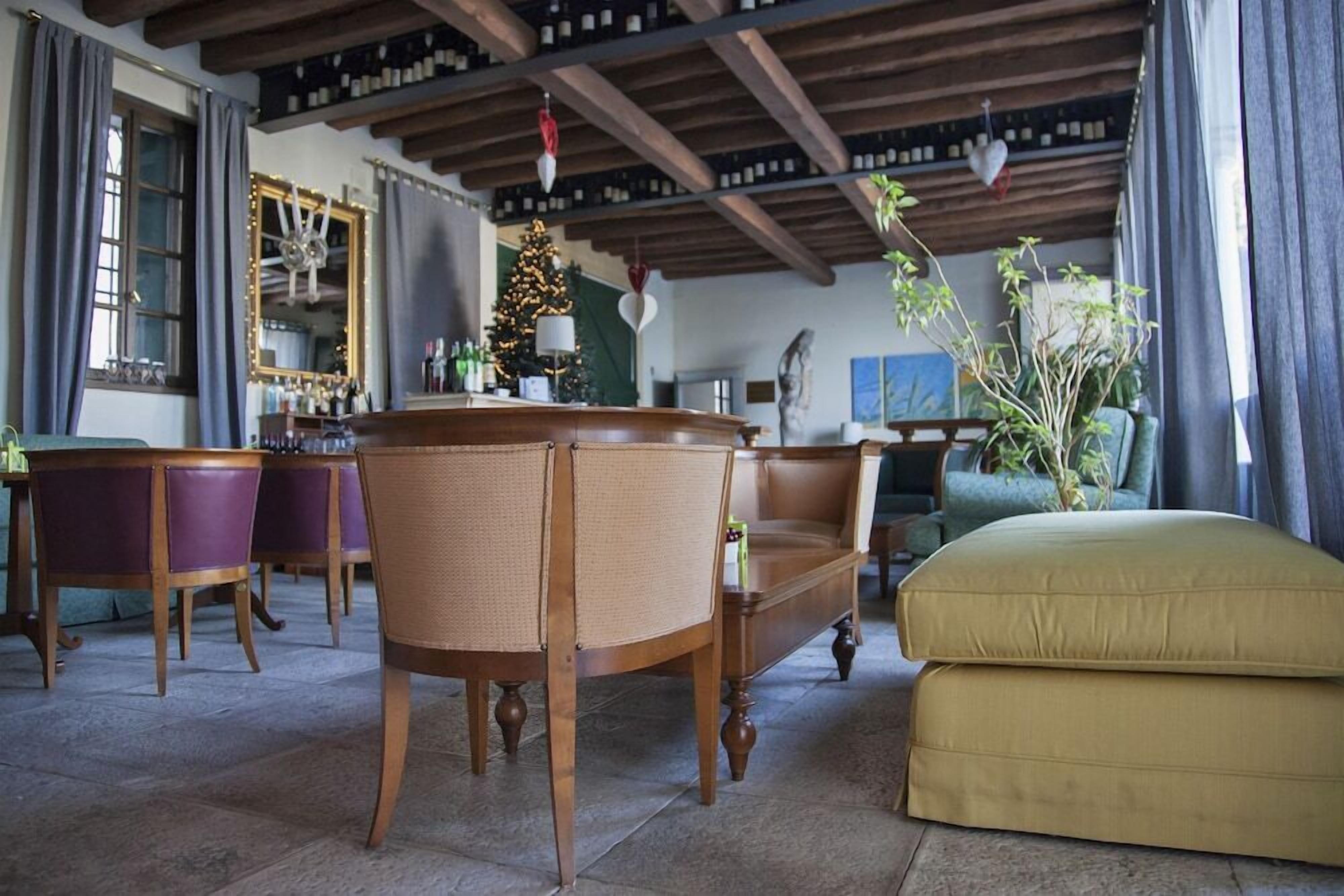 A cozy living room with a wooden coffee table, purple chairs, a sofa, and a yellow ottoman.
