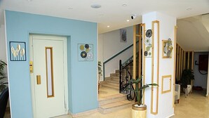 A modern interior with a light blue wall, a white door, a staircase with black railings, and decorative plates on the wall. - Lamera Hotel. (Hurghada)