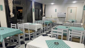 A restaurant with checkered tablecloths, white chairs, and a checkered floor pattern. - Lamera Hotel. (Hurghada)