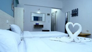 A hotel room with two beds, a mirror, a small shelf, and a heart-shaped towel arrangement. - Lamera Hotel. (Hurghada)