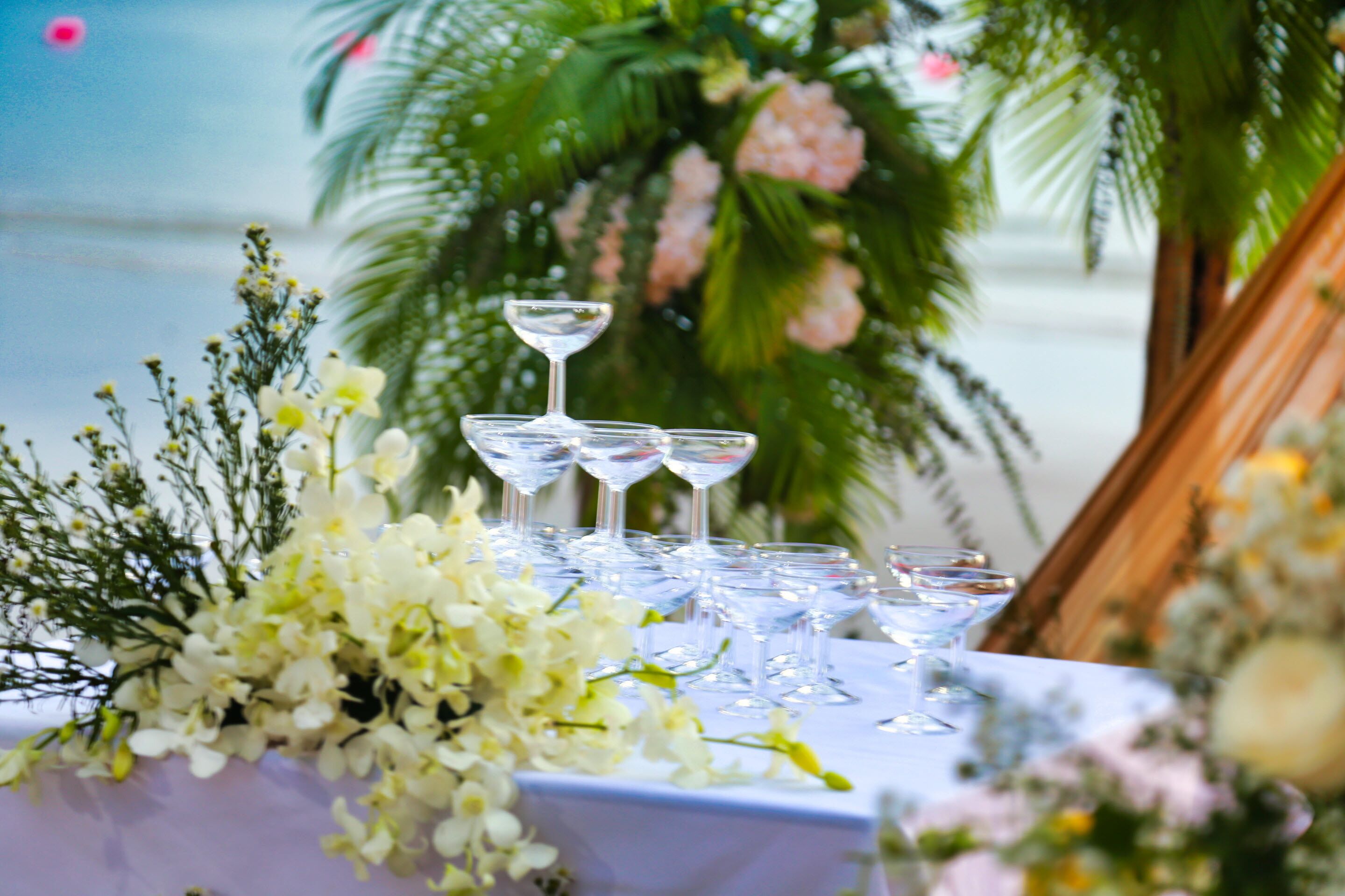 A table set with multiple wine glasses and a floral arrangement.