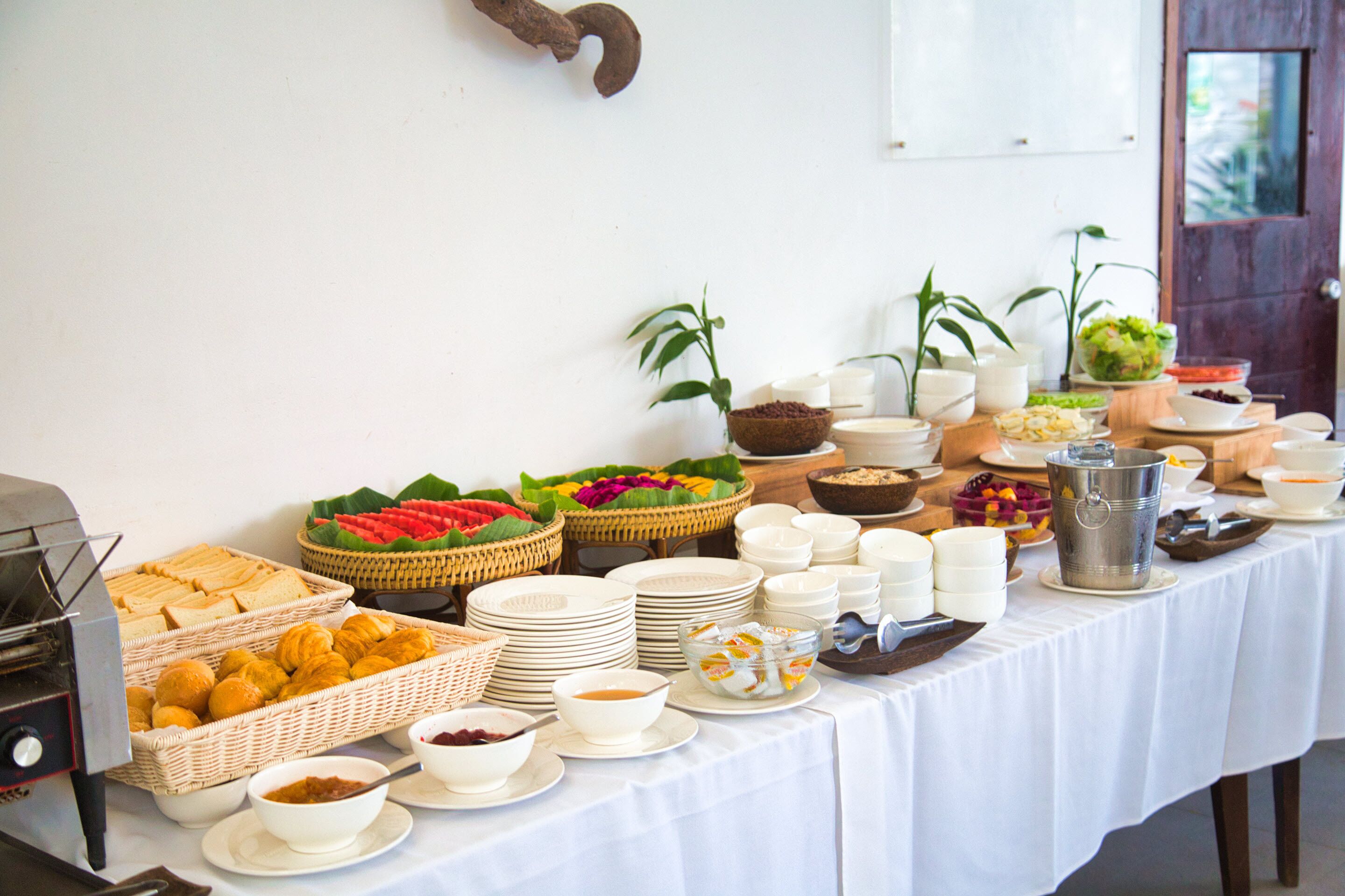 A buffet table with various food items and dishes.