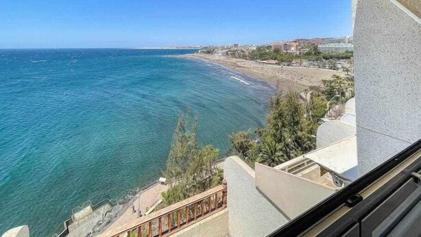 A balcony with a view of the ocean and a beach. - Ocean Front Apartment (Maspalomas)