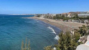 A coastal cityscape with a beach, buildings, and clear skies. - Ocean Front Apartment (Maspalomas)