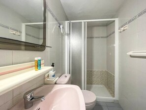 Une salle de bain avec un lavabo, des toilettes et une douche.