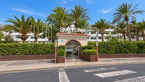 A hotel entrance with a sign reading 'SURYCAN' and a gated driveway.