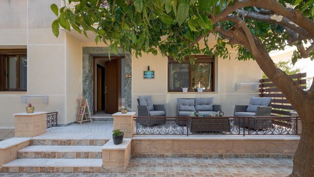A patio area with outdoor seating, a stone staircase, and a door leading to the interior.