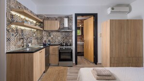 A compact kitchen with a stove, oven, and wooden cabinets.