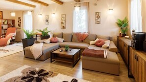 A spacious living room with a sofa set, a coffee table, and a TV stand.