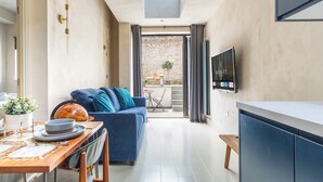 Eine moderne Küche mit Essbereich, einer Couch und einem Fernseher.