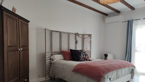 Ein Schlafzimmer mit einem Bett, einem Kleiderschrank und einem Fenster mit Vorhängen.
