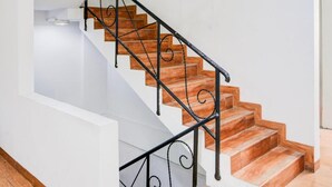 Una escalera con escalones de madera y barandillas de metal negro.