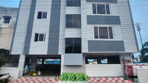 A multi-story building with a flat roof, large windows, and a checkered pattern on the ground. - Hotel Ocean View Vizag (Visakhapatnam)