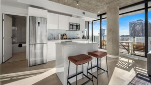 Eine moderne Küche mit Kochinsel, Edelstahlgeräten und Blick auf die Stadt.