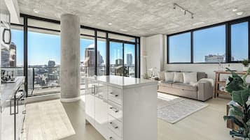 Enjoy a panoramic city view from the large window in this apartment's spacious living area.