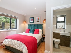 Une chambre à coucher avec un lit, une fenêtre, une tête de lit et une vue sur l’extérieur.