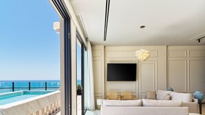 A modern living room with a large TV, a sofa, and a dining area.