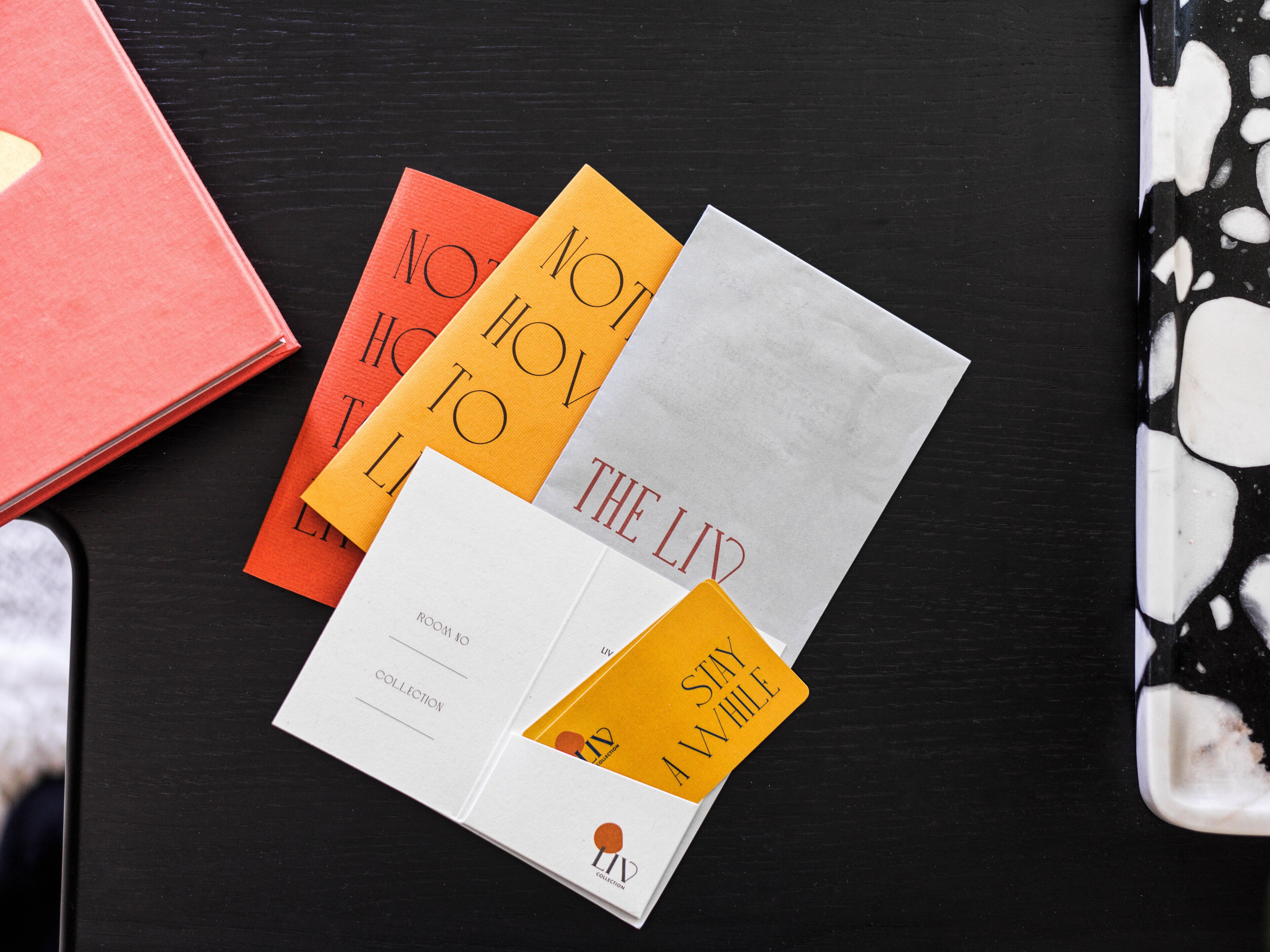 Una colección de libros con texto visible en sus portadas, sobre una superficie oscura.