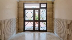 A hallway with a large, dark-framed glass door leading to an outdoor area. - Spallanzani-San Camillo, apartment for 4 people (Roma)