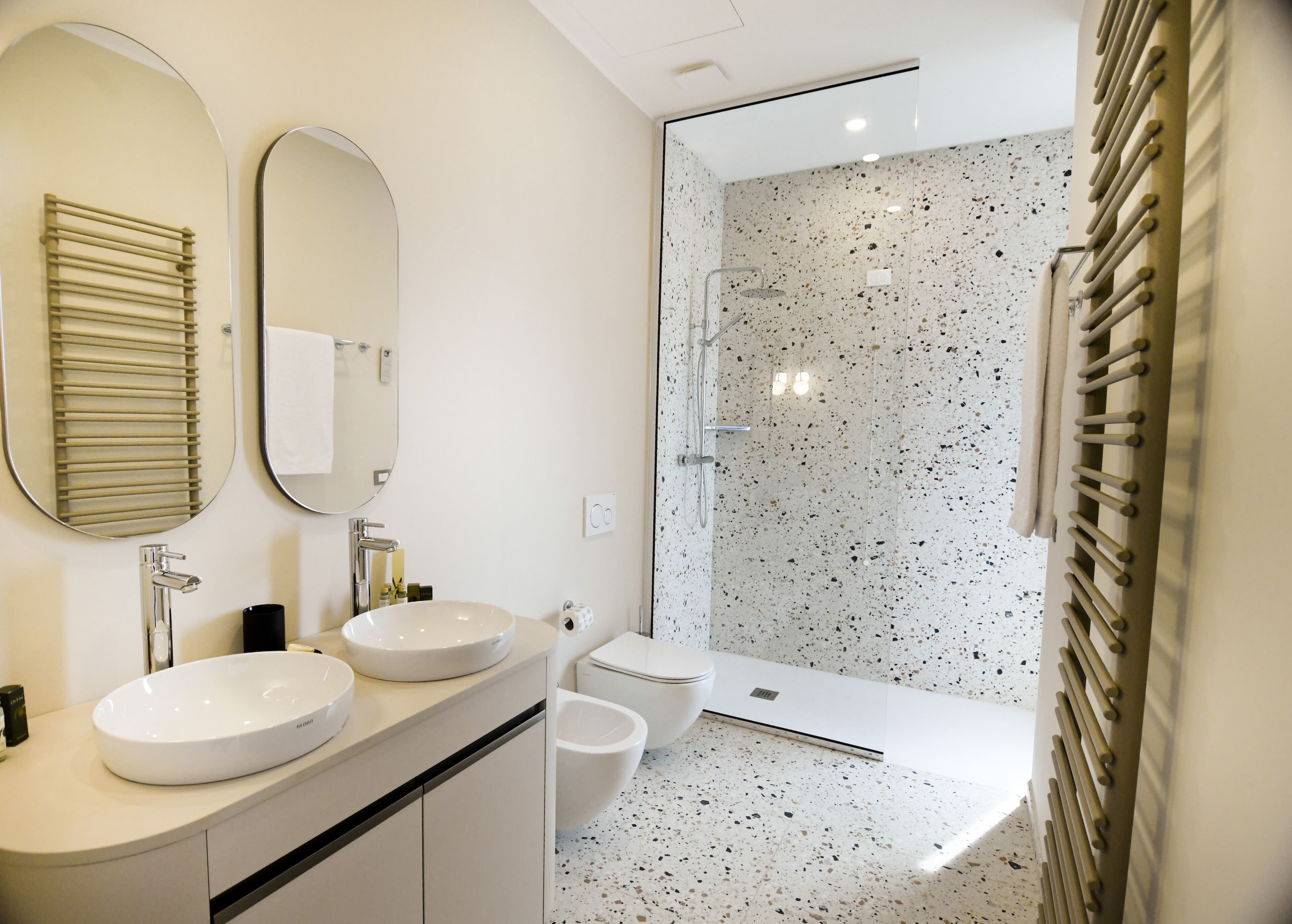 Un baño moderno con dos lavamanos, un inodoro y una ducha.