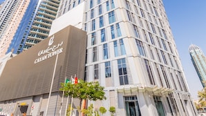 Een hoog, modern hotel met een opvallende, gebogen gevel en een prominente entree.