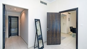 A hallway with a mirror, a wardrobe, and a door leading to a bathroom. - Cozy 1BR at Torch Tower Dubai Marina by Deluxe Holiday Homes (Dubai)
