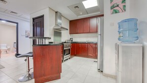 Una cocina moderna con armarios de madera, una campana extractora de acero inoxidable y un dispensador de agua.