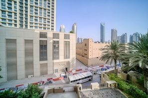 A modern urban area with high-rise buildings, a bus, and palm trees.