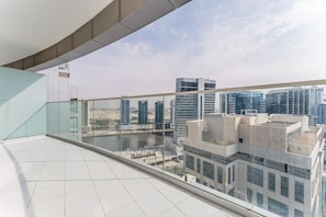 A high-rise building with a glass balcony overlooking a cityscape.