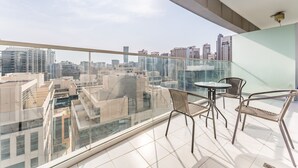 A balcony with a city view, glass railings, and two wicker chairs. - Serene Canal Views from a Spacious Balcony, Just Steps from the Bus Stop (Dubai)