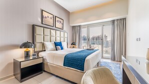 A modern hotel room with a large bed, a desk, a chair, a TV, and a balcony with a city view. - Serene Canal Views from a Spacious Balcony, Just Steps from the Bus Stop (Dubai)