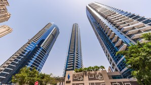 A modern hotel with a distinctive geometric facade, multiple floors, and a prominent logo. - Cozy 1BR at Bay Central 1 Dubai Marina by Deluxe Holiday Homes (Dubai)