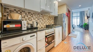 Une cuisine moderne équipée d’un lave-linge, d’une cuisinière et d’un four à micro-ondes.