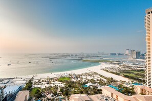 A coastal resort with beachfront villas, a marina, and a large hotel building. - Exquisite 1BR in Sadaf, Jumeirah Beach Residence by Deluxe Holiday Homes (Dubai)